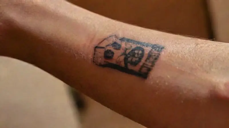 Close-up of freckled arm with tattoo